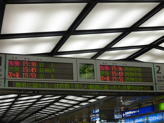 神戸市営地下鉄の電光掲示板、中央に時計、その両サイドに先発次発の電車の表記、その下に消費生活センターからのお知らせが字幕で表示されている